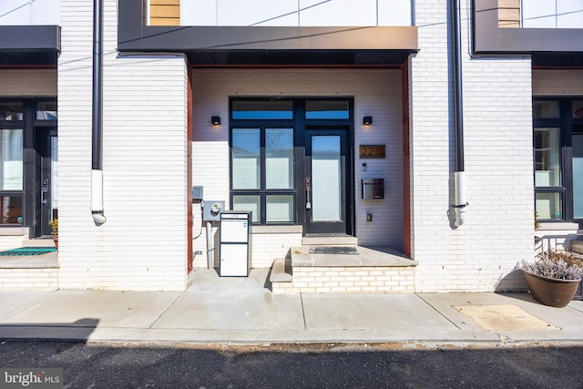 doorway to property featuring brick siding