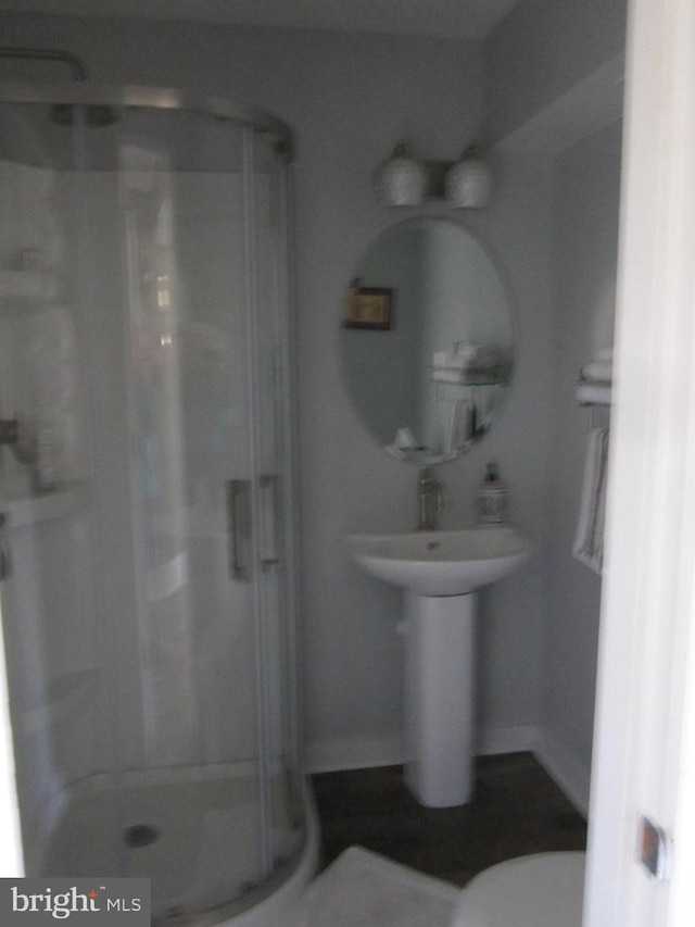 bathroom featuring a stall shower and toilet