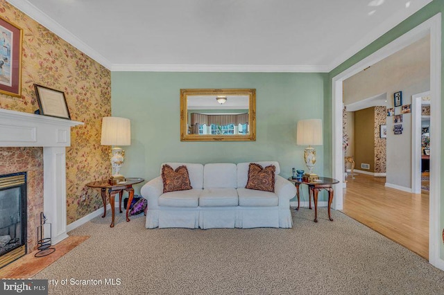 carpeted living area featuring ornamental molding, baseboards, and a premium fireplace