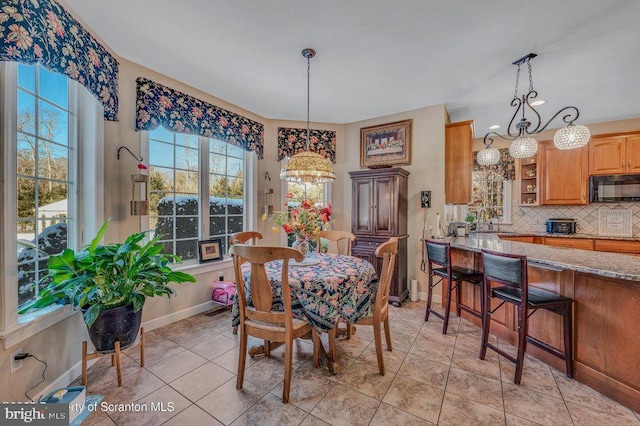 dining area featuring light tile patterned flooring and baseboards