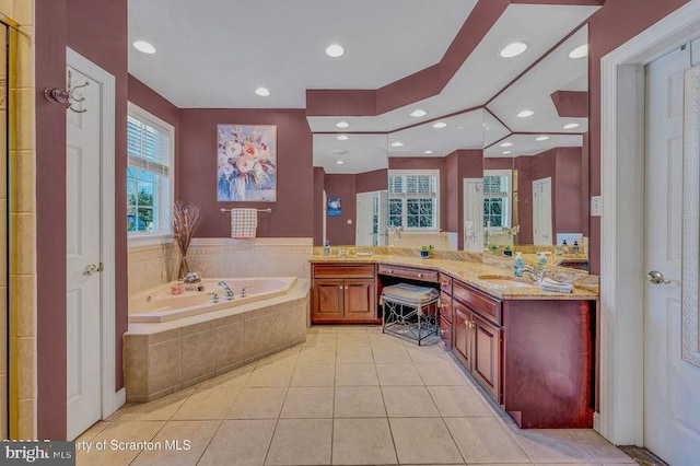 bathroom with a garden tub, recessed lighting, vanity, and tile patterned floors