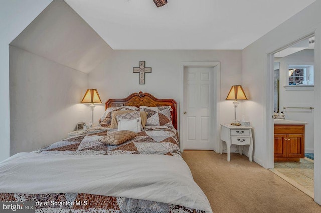 bedroom featuring ensuite bathroom and light colored carpet