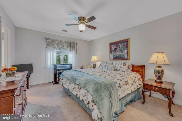 bedroom with baseboards, visible vents, ceiling fan, and light colored carpet