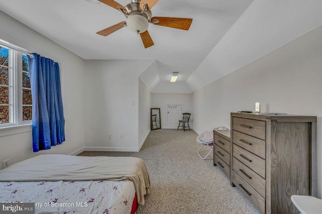 carpeted bedroom with vaulted ceiling, baseboards, and ceiling fan