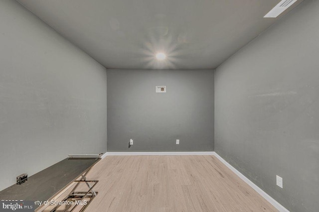 empty room with visible vents, baseboards, and wood finished floors