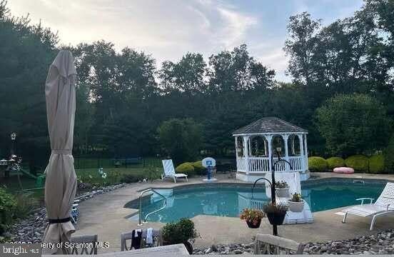 outdoor pool featuring a gazebo and a patio area