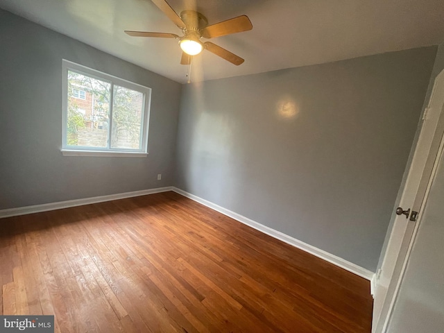 unfurnished room with hardwood / wood-style floors, a ceiling fan, and baseboards