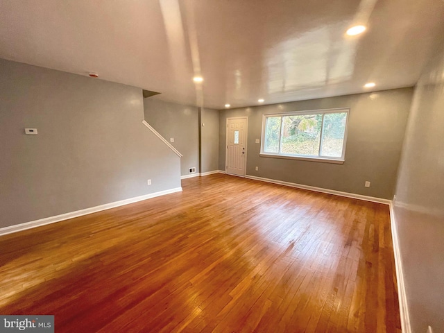 empty room with recessed lighting, wood-type flooring, and baseboards