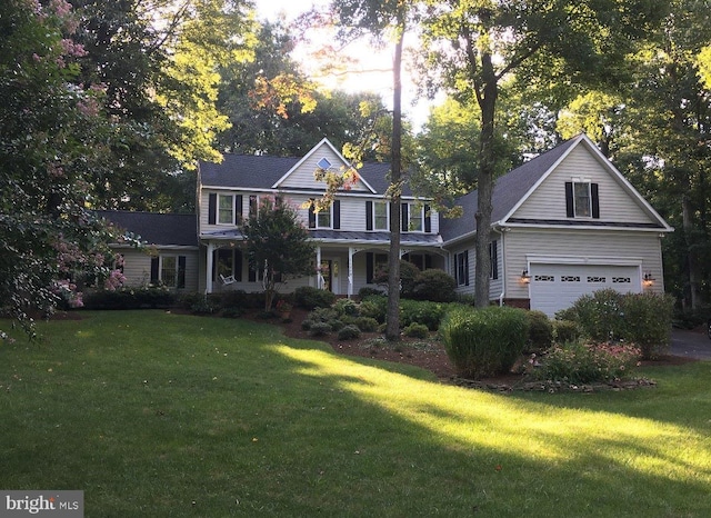 view of front of home with a front yard, a porch, and an attached garage