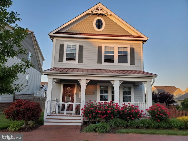 view of front facade with covered porch, metal roof, and a standing seam roof