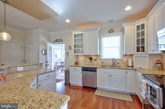 kitchen featuring a sink, white cabinets, wood finished floors, and stainless steel appliances