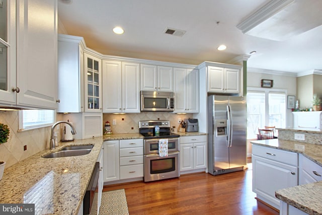 kitchen featuring dark wood-style floors, visible vents, a sink, stainless steel appliances, and white cabinets