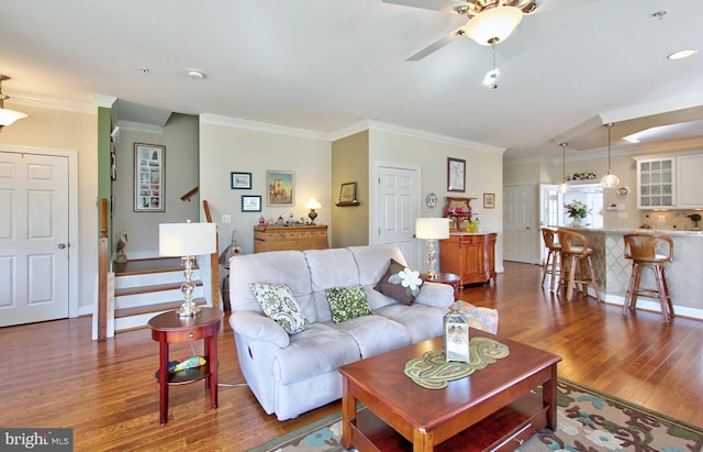 living area featuring ceiling fan, baseboards, stairs, ornamental molding, and wood finished floors