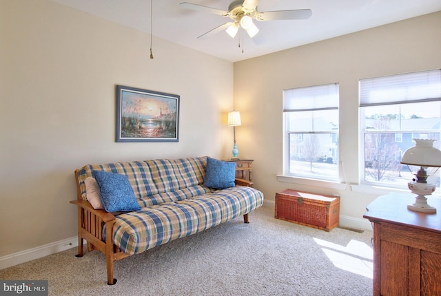 carpeted living area featuring a ceiling fan and baseboards