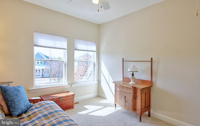 sitting room featuring carpet, baseboards, and ceiling fan