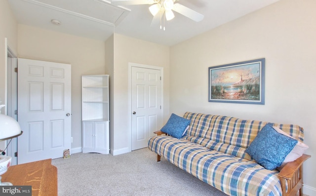 living room featuring baseboards, attic access, carpet, and a ceiling fan