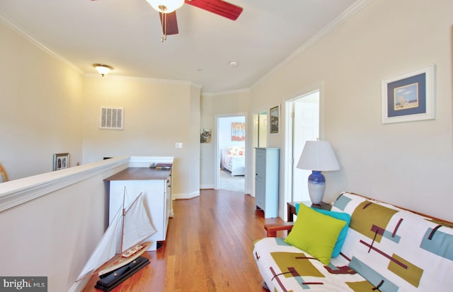 interior space featuring visible vents, baseboards, wood finished floors, and ornamental molding