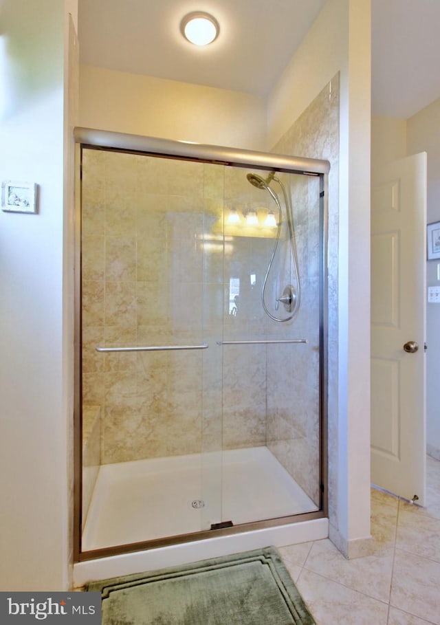 full bath with a shower stall and tile patterned floors