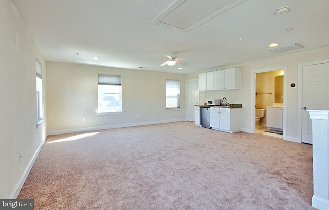 unfurnished living room with recessed lighting, baseboards, light colored carpet, and attic access