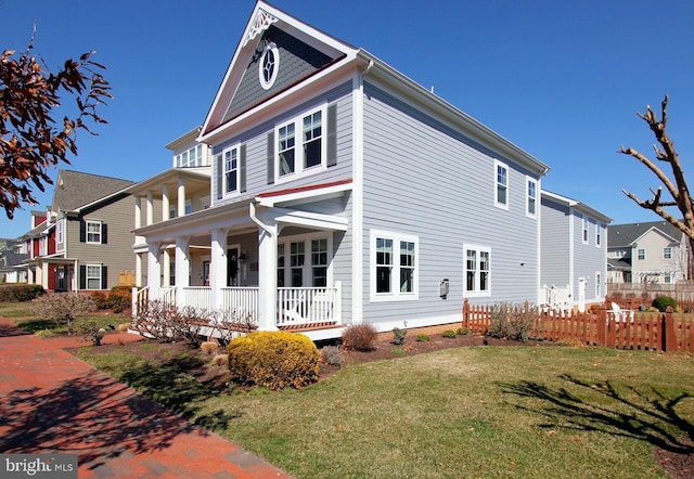 exterior space with a yard, a residential view, covered porch, and fence