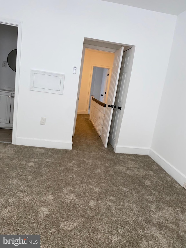 carpeted spare room featuring baseboards