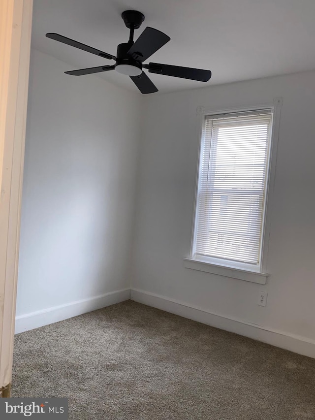 empty room featuring carpet floors, baseboards, and a ceiling fan