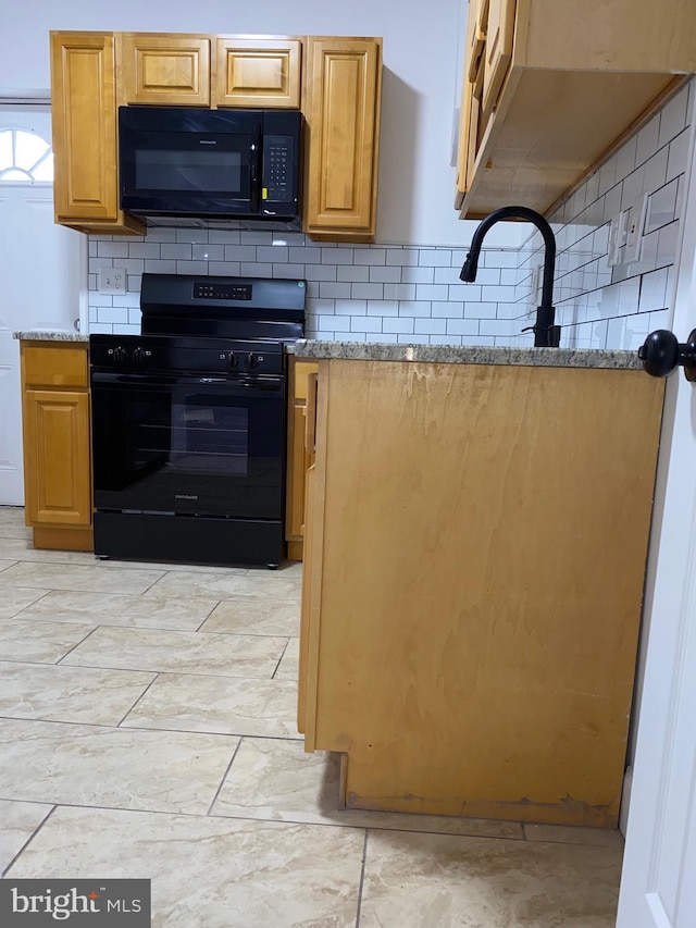 kitchen with black appliances, backsplash, and light stone countertops