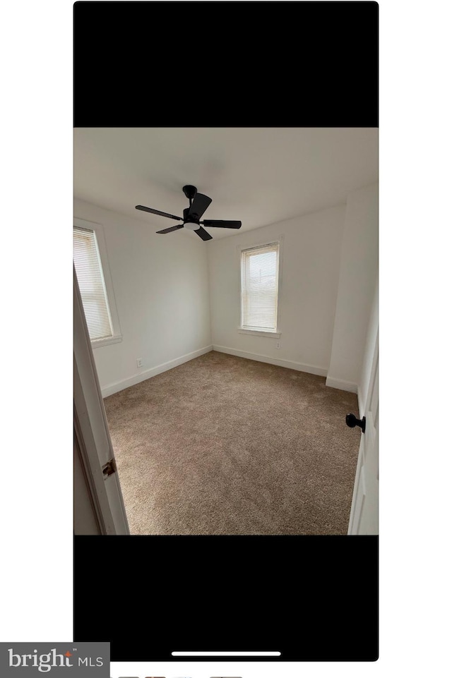 empty room with ceiling fan, carpet, and baseboards