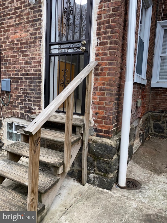 doorway to property featuring brick siding