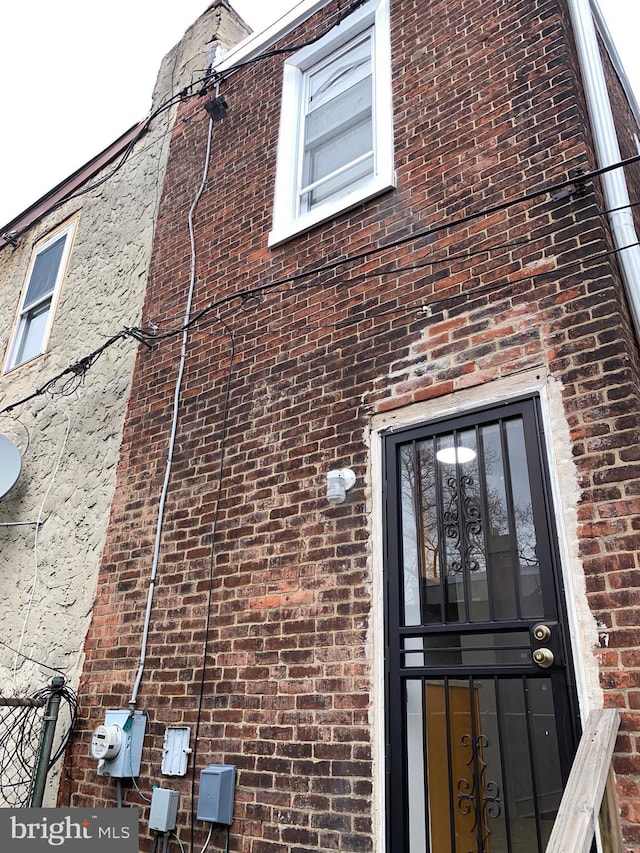 view of exterior entry with brick siding