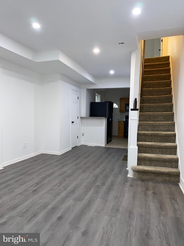 unfurnished living room with stairs, dark wood-style floors, and recessed lighting