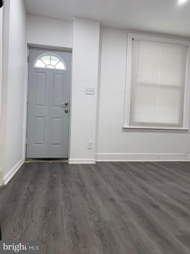 foyer with baseboards and dark wood-type flooring