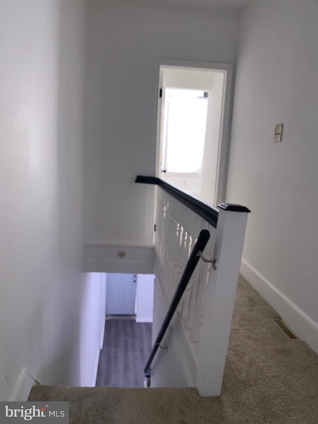 stairway featuring carpet and baseboards