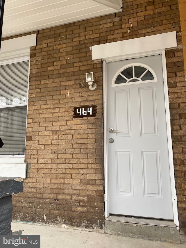 entrance to property featuring brick siding