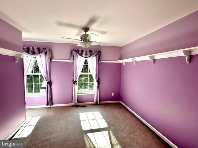 empty room featuring visible vents, baseboards, carpet, and ceiling fan