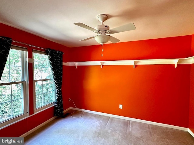 empty room featuring baseboards, carpet floors, and ceiling fan