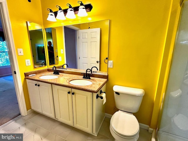 bathroom with a sink, toilet, and double vanity