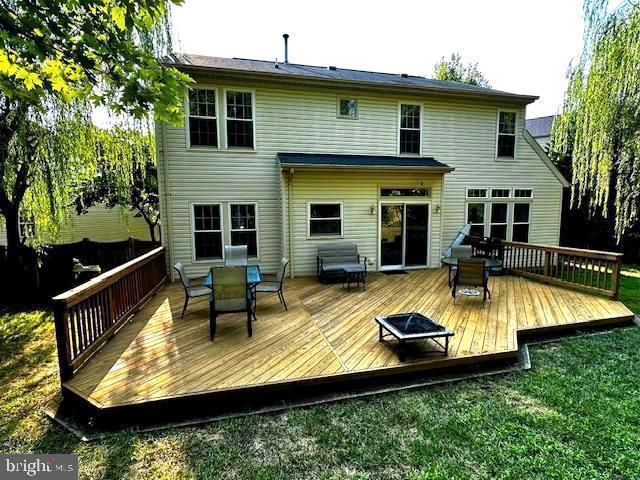 back of property with a wooden deck and outdoor dining space