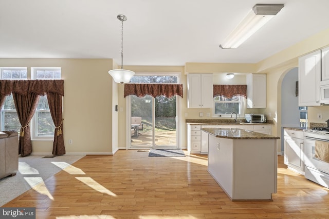 kitchen with white appliances, white cabinets, and light wood finished floors