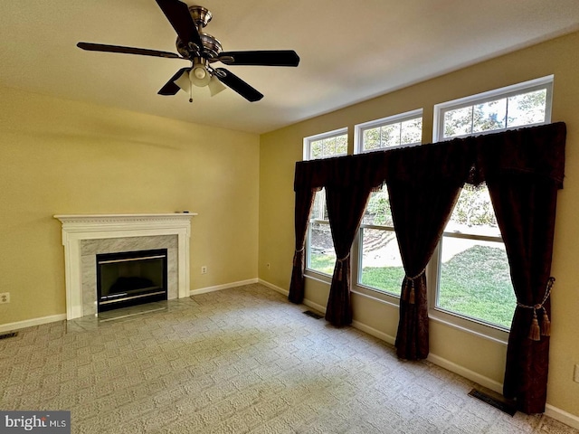 unfurnished living room featuring a high end fireplace, visible vents, and baseboards