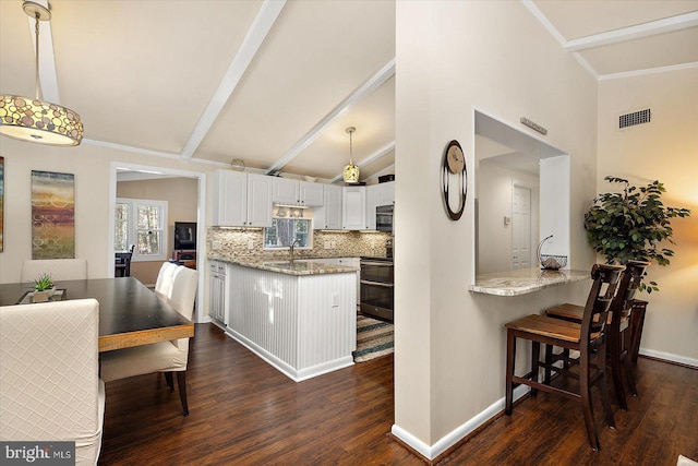 kitchen with visible vents, light stone countertops, double oven range, lofted ceiling with beams, and a peninsula