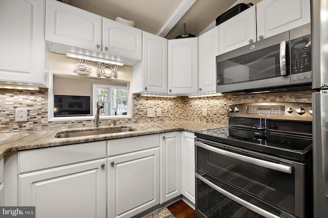 kitchen with stainless steel microwave, double oven range, decorative backsplash, and a sink