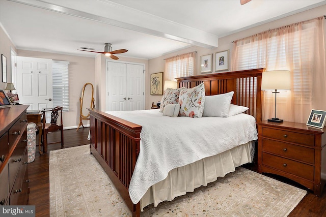 bedroom with ceiling fan, baseboards, beam ceiling, a closet, and dark wood-style flooring