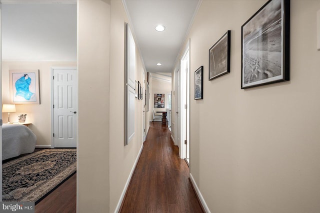 hall featuring dark wood-type flooring, recessed lighting, and baseboards