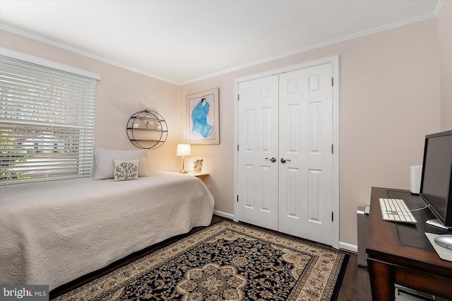 bedroom featuring a closet, crown molding, baseboards, and wood finished floors