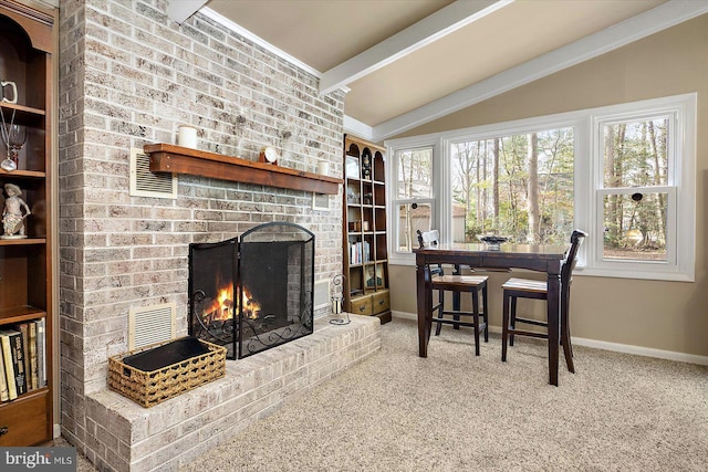 carpeted dining space with lofted ceiling with beams, a brick fireplace, visible vents, and baseboards