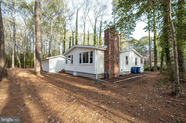 exterior space featuring an outdoor structure and a chimney