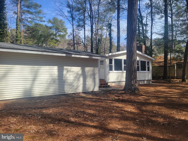 view of side of property featuring entry steps and a chimney