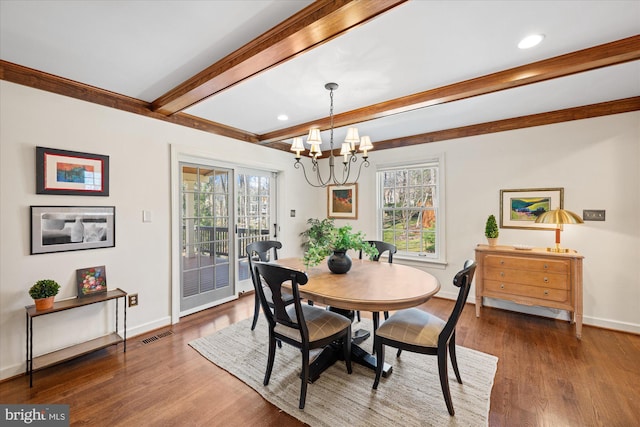 dining area featuring beamed ceiling, visible vents, a notable chandelier, wood finished floors, and baseboards