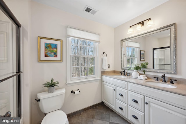 full bath featuring a sink, visible vents, toilet, and double vanity